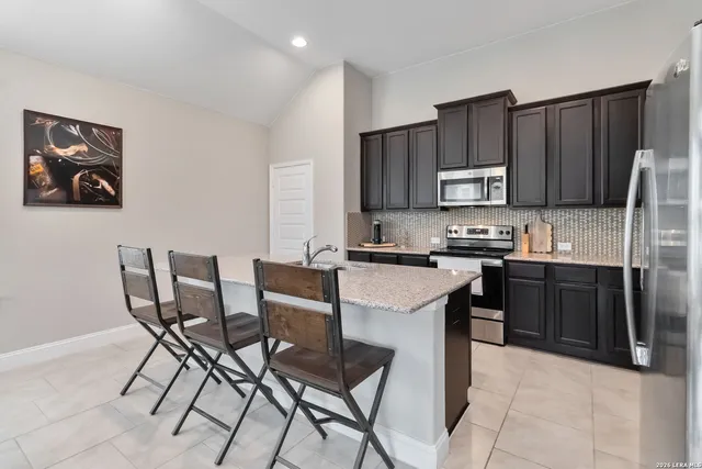 a kitchen with a stove a sink a dining table and chairs