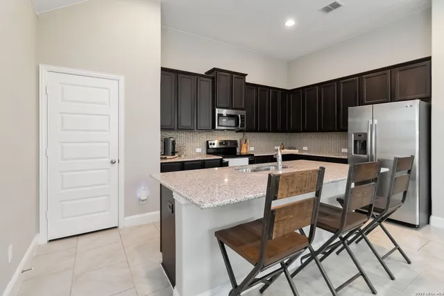 a kitchen with stainless steel appliances a stove a refrigerator and a refrigerator with wooden cabinets