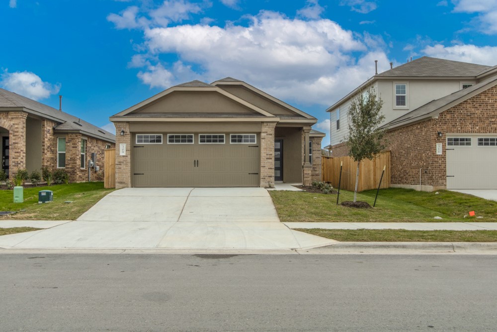 309 Canley Loop Hutto, TX 78634 - Photo 1 of 27 a front view of a house with a garden