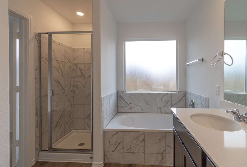 309 Canley Loop Hutto, TX 78634 - Photo 20 of 27 a bathroom with a granite countertop sink a mirror and shower