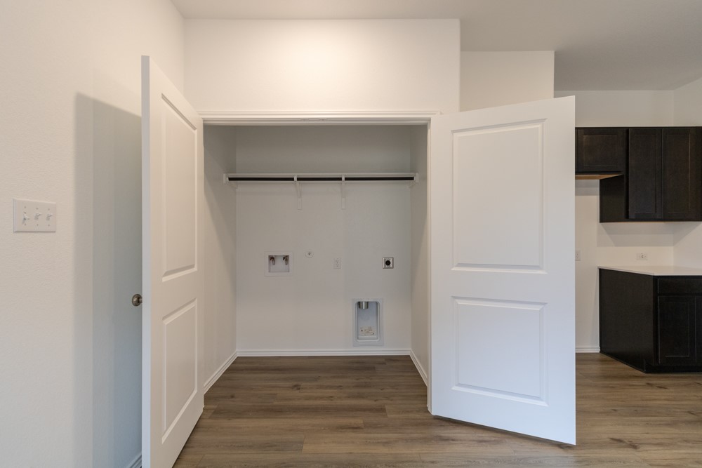 309 Canley Loop Hutto, TX 78634 - Photo 23 of 27 a view of an empty room with wooden floor and a fireplace