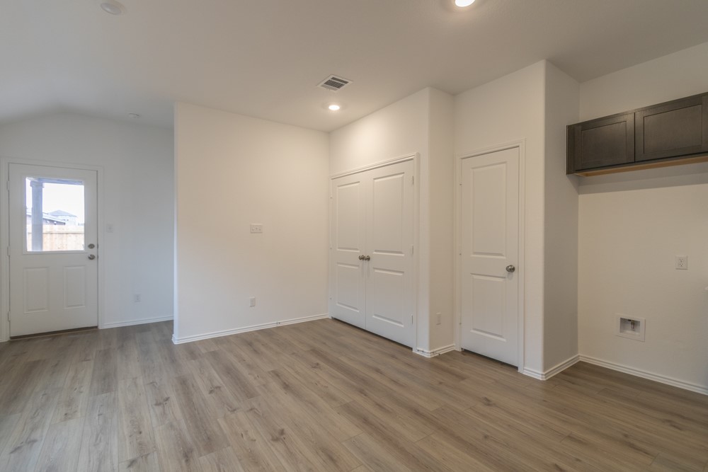 309 Canley Loop Hutto, TX 78634 - Photo 6 of 27 a view of an empty room with wooden floor and a window