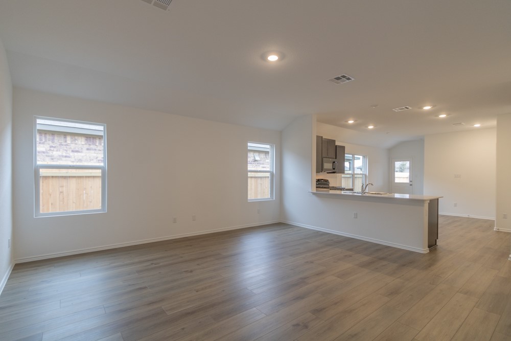 309 Canley Loop Hutto, TX 78634 - Photo 9 of 27 an empty room with wooden floor and windows