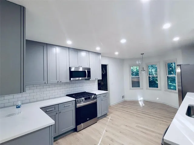 a view of a hallway with wooden floor and a chandelier