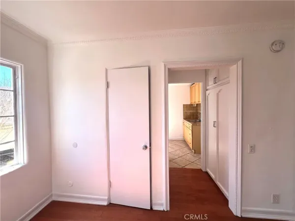an empty room with wooden floor and a bathroom