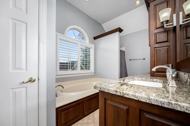 a view of a backyard with chairs and table under an umbrella