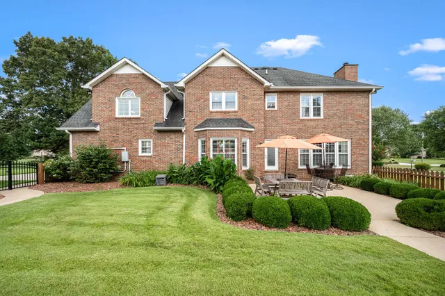 an aerial view of a house with a yard and lake view