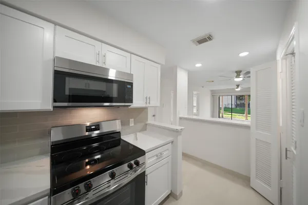 a kitchen with stainless steel appliances a stove microwave and sink