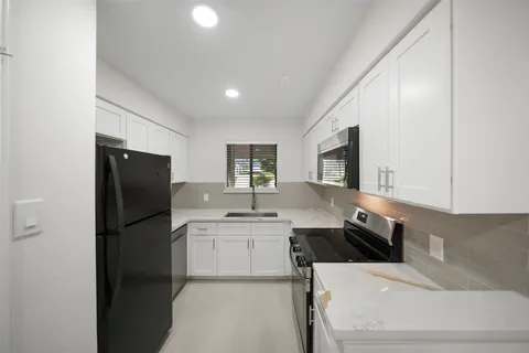 a kitchen with a sink stainless steel appliances and cabinets