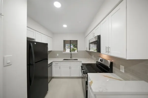 a kitchen with a sink stainless steel appliances and cabinets