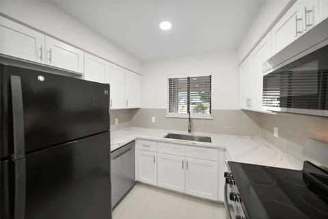 a kitchen with a sink stainless steel appliances and cabinets