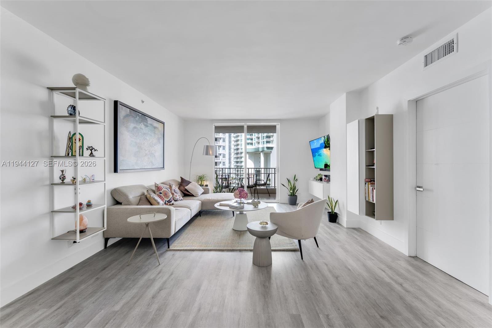 a living room with furniture and a wooden floor