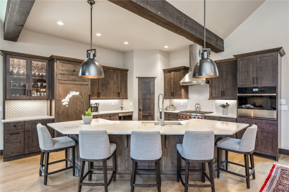 380 River Park Drive Breckenridge, CO 80424 - Photo 6 of 45 a kitchen with stainless steel appliances kitchen island granite countertop a dining table chairs and white cabinets