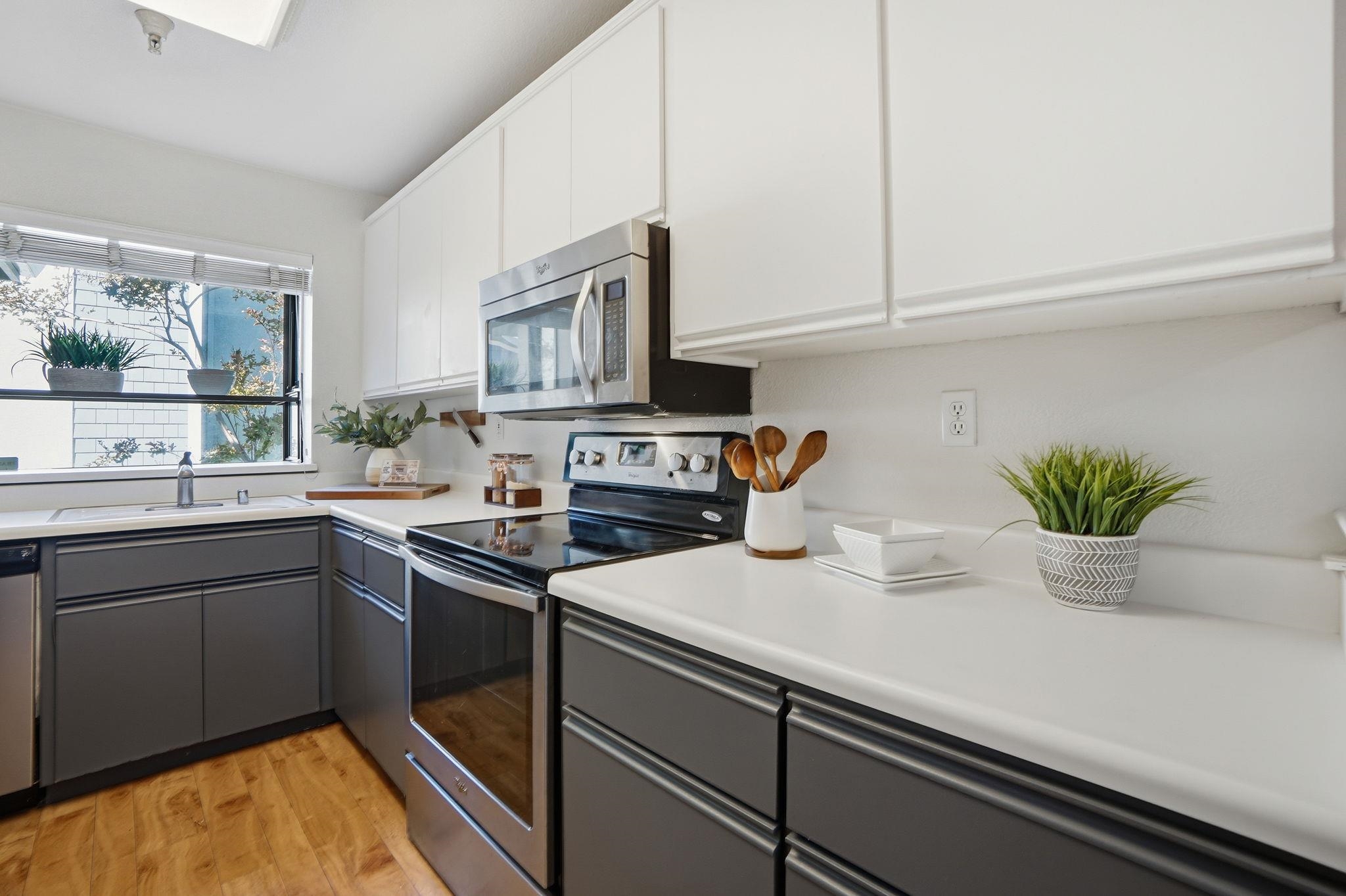 2586 Oak Road, Unit 229 Walnut Creek, CA 94597 - Photo 6 of 39 a kitchen with stainless steel appliances granite countertop a sink a stove and a microwave