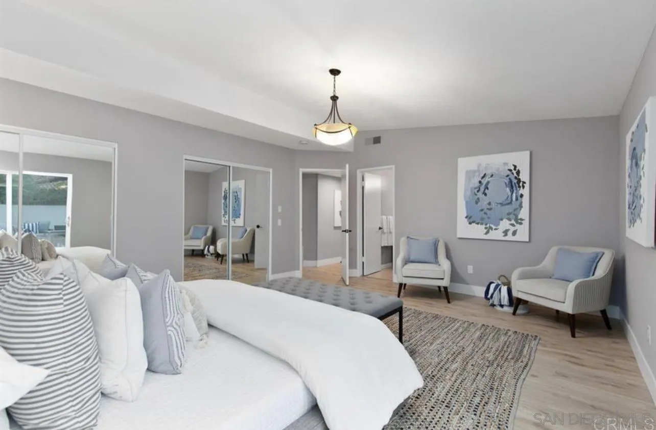 5957 Avenida Chamnez La Jolla, CA 92037 - Photo 10 of 28 a bedroom with bed and a chandelier