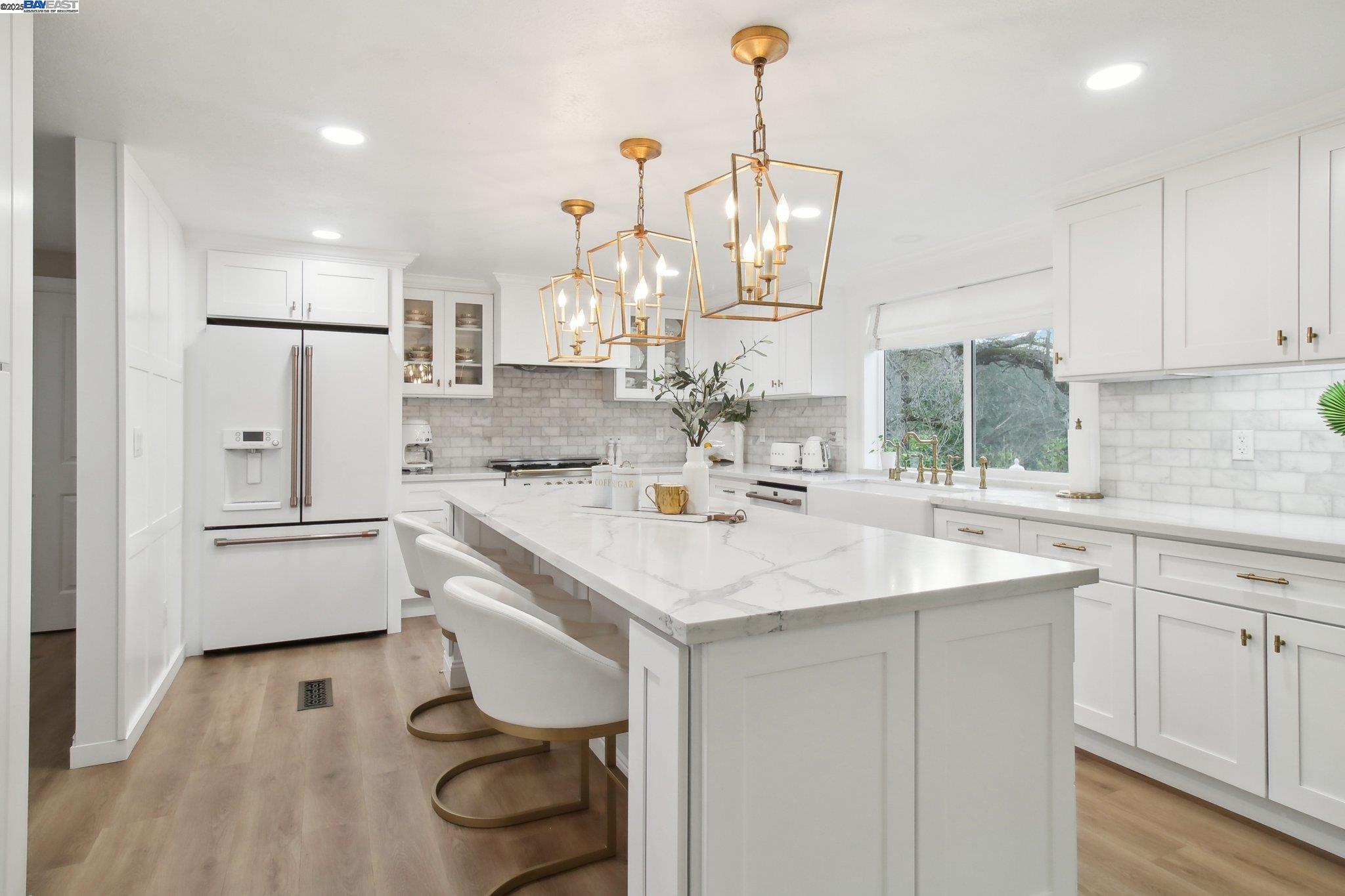 484 El Pintado Road Danville, CA 94526 - Photo 11 of 60 a kitchen with kitchen island a sink a stove a refrigerator and white cabinets with wooden floor