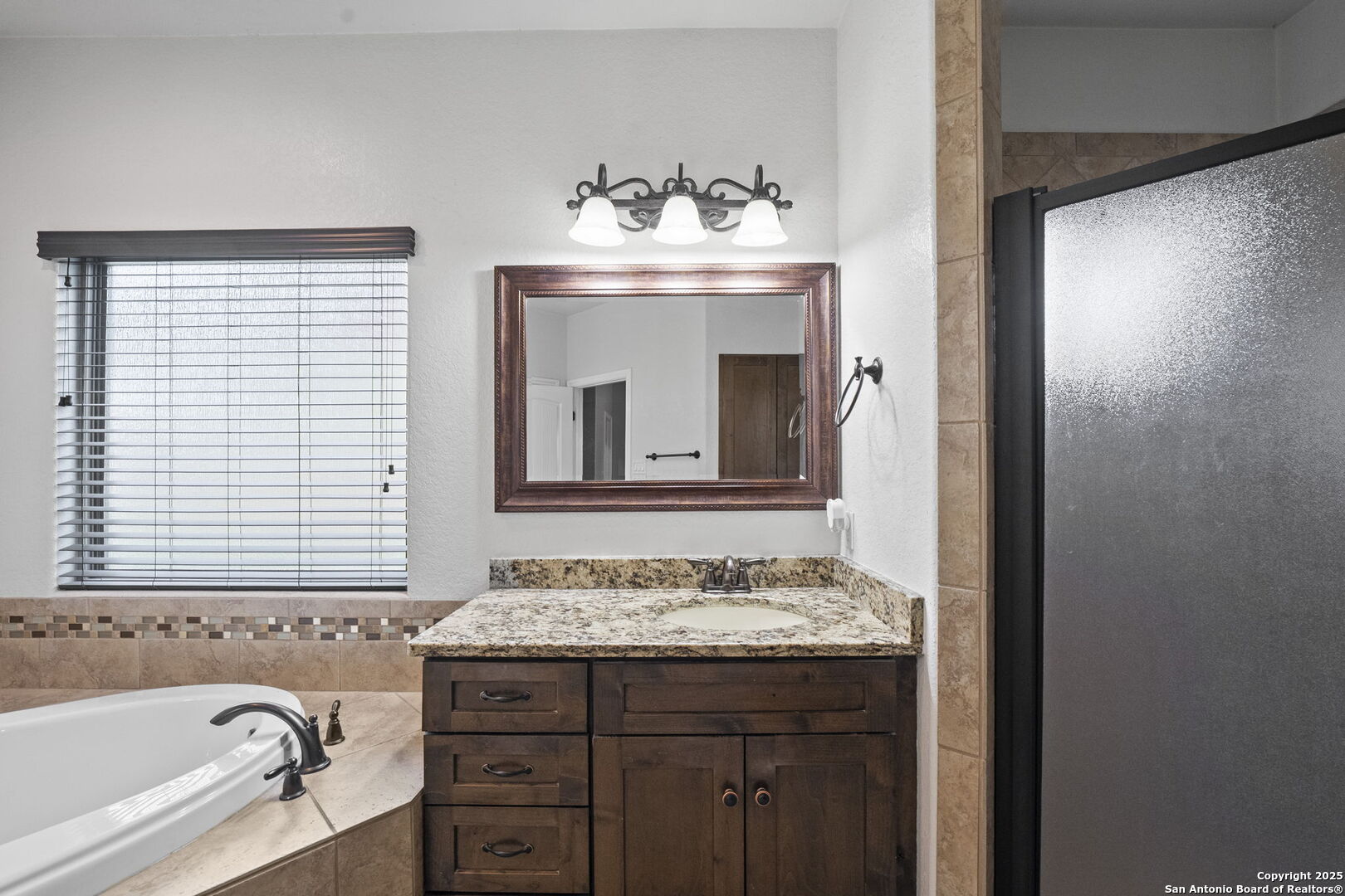622 North Dickson Street Poth, TX 78147 - Photo 29 of 60 a bathroom with a granite countertop sink and a mirror