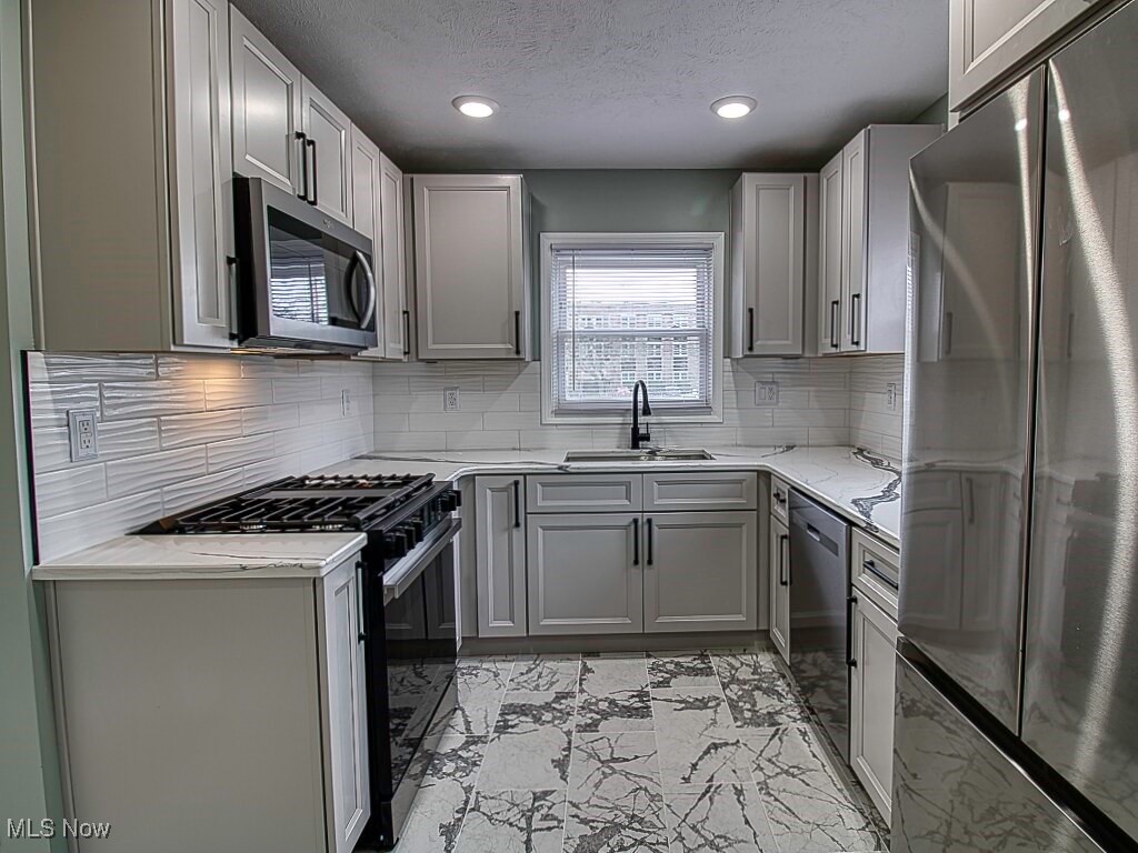 5840 Pearl Road Cleveland, OH 44130 - Photo 10 of 39 Kitchen with sleek finishes, stone counters, 2025 stainless steel appliances, tile flooring.