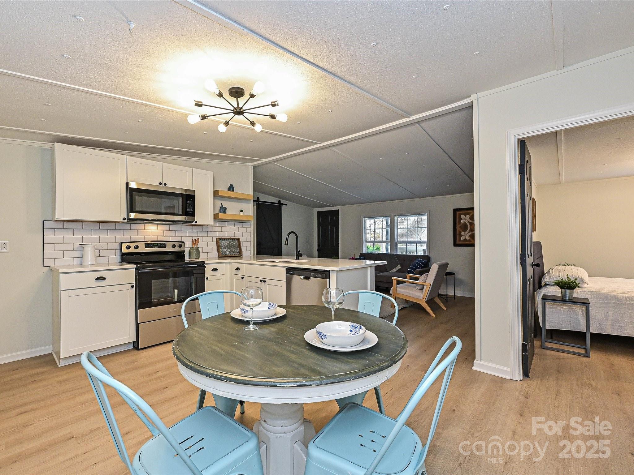 3318 Loop Road Lincolnton, NC 28092 - Photo 12 of 27 a view of a dining room with furniture a chandelier and kitchen view