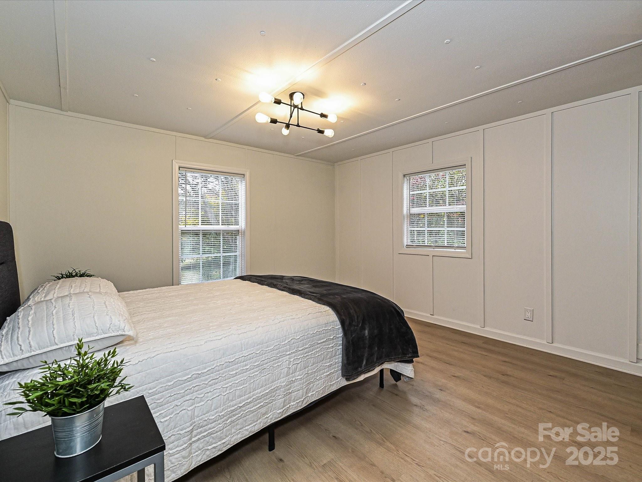 3318 Loop Road Lincolnton, NC 28092 - Photo 13 of 27 a bedroom with a large bed and a chandelier