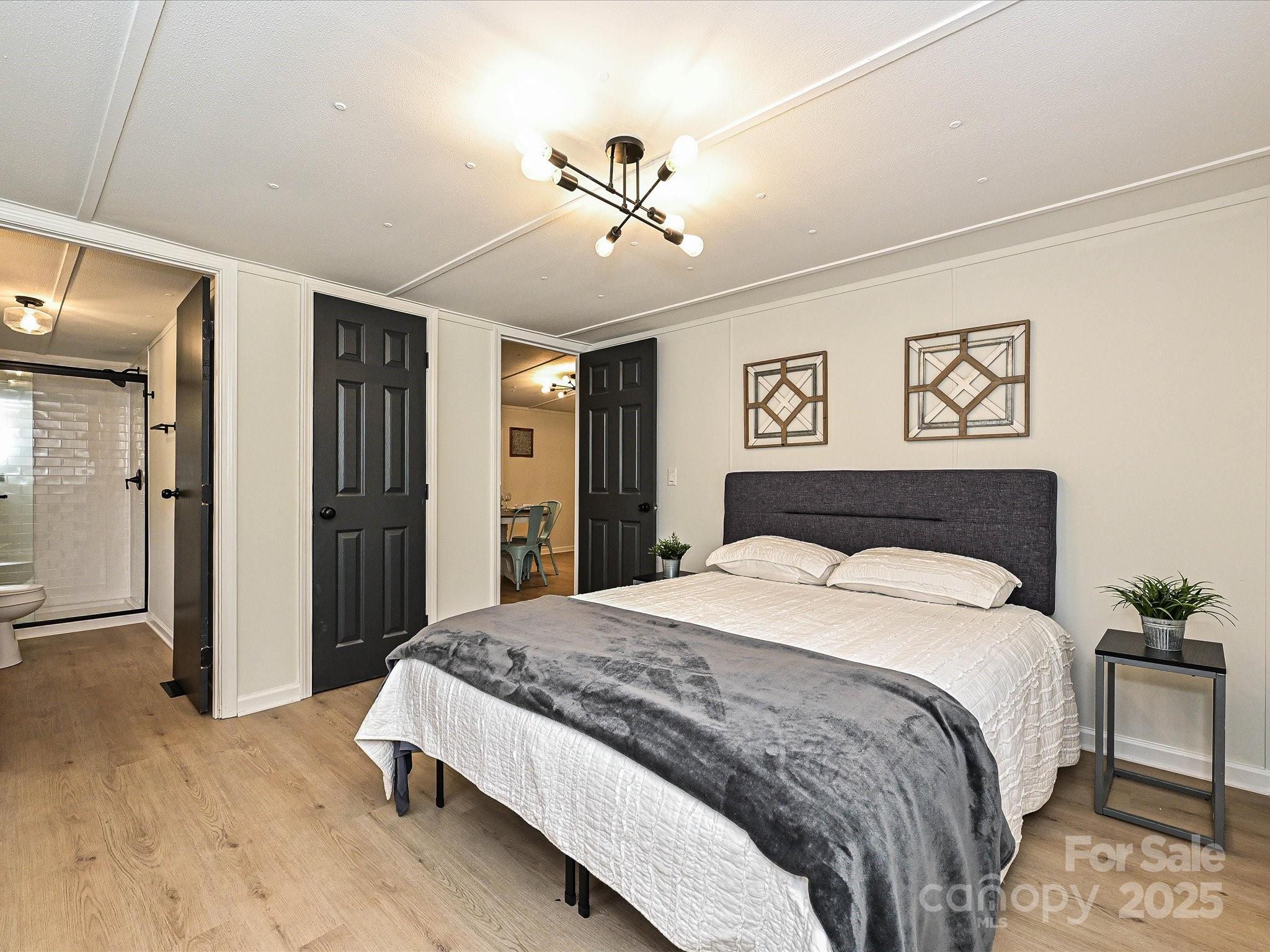 3318 Loop Road Lincolnton, NC 28092 - Photo 14 of 27 a spacious bedroom with a large bed and a chandelier