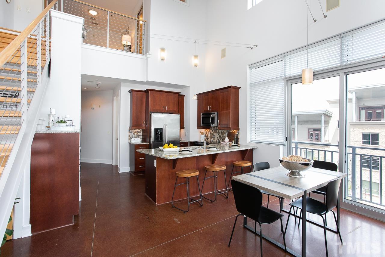 2608 Erwin Road, Unit 402 Durham, NC 27705 - Photo 8 of 33 a kitchen with stainless steel appliances granite countertop a table chairs sink and wooden cabinets