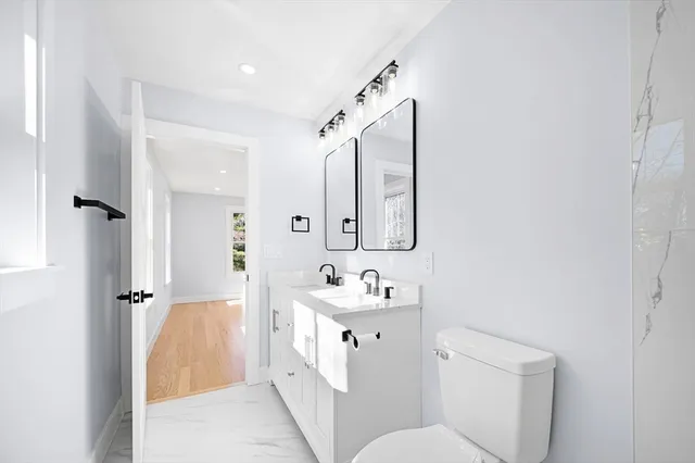 a bathroom with a sink toilet vanity and shower