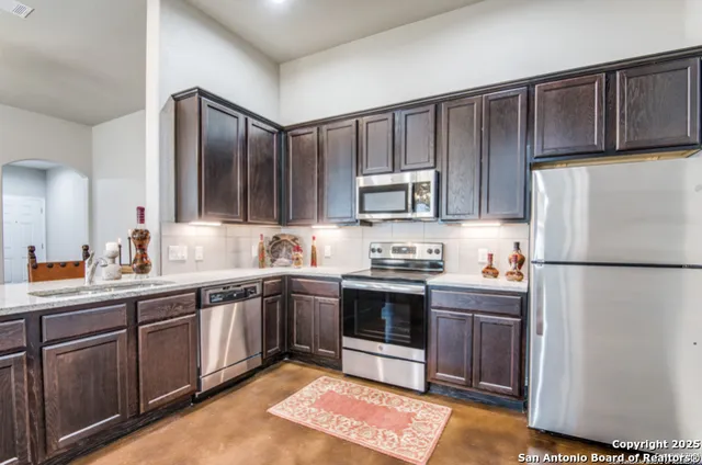 a kitchen with stainless steel appliances granite countertop a refrigerator sink and cabinets