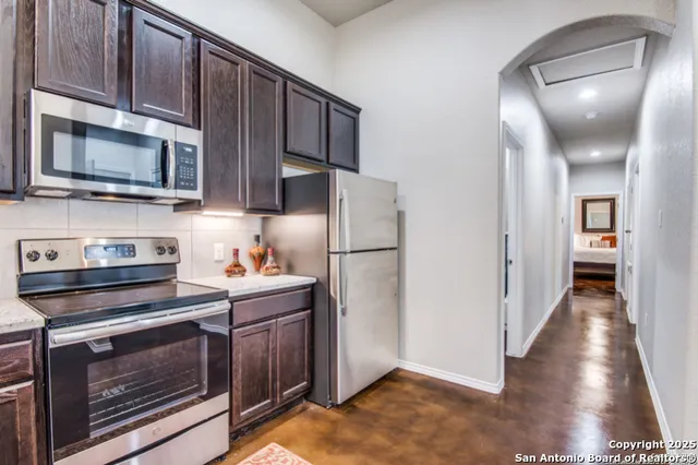 a kitchen with stainless steel appliances a stove a microwave and a refrigerator