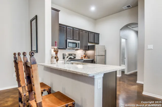 a kitchen with kitchen island a sink stove and refrigerator