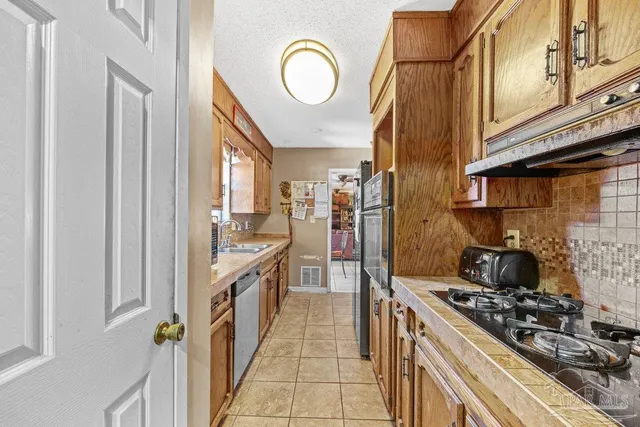 a kitchen with stainless steel appliances granite countertop a stove and a refrigerator