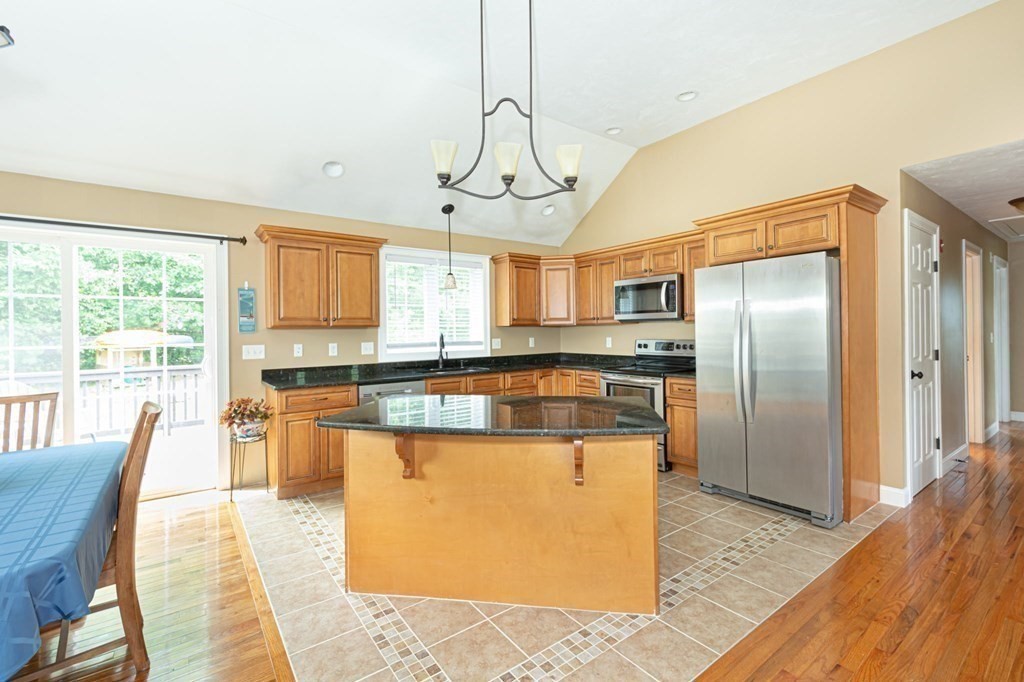 280 Maple Avenue Rutland, MA 01543 - Photo 8 of 35 a kitchen with stainless steel appliances granite countertop a refrigerator a stove top oven a sink dishwasher a dining table and chairs with wooden floor
