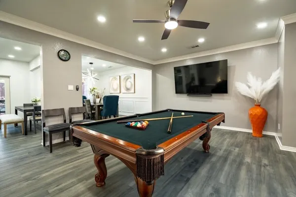 a living room with furniture pool table and a flat screen tv