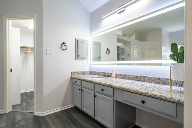 a bathroom with a granite countertop sink and a mirror