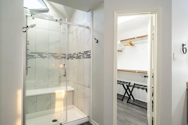 a bathroom with a glass shower door and a window