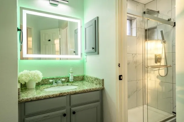 a bathroom with a granite countertop sink and a mirror