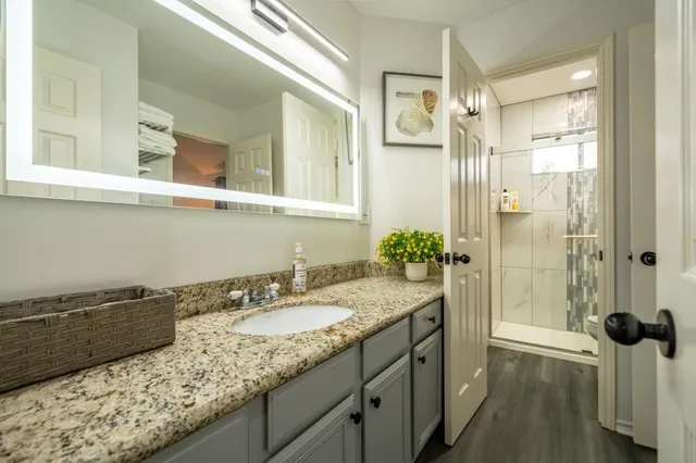 a bathroom with a granite countertop sink and a mirror