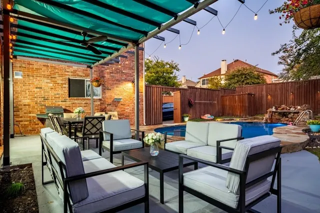 a view of a patio with a dining table and chairs with a small yard