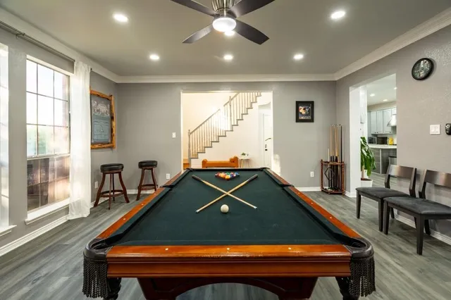 a room with pool table and windows