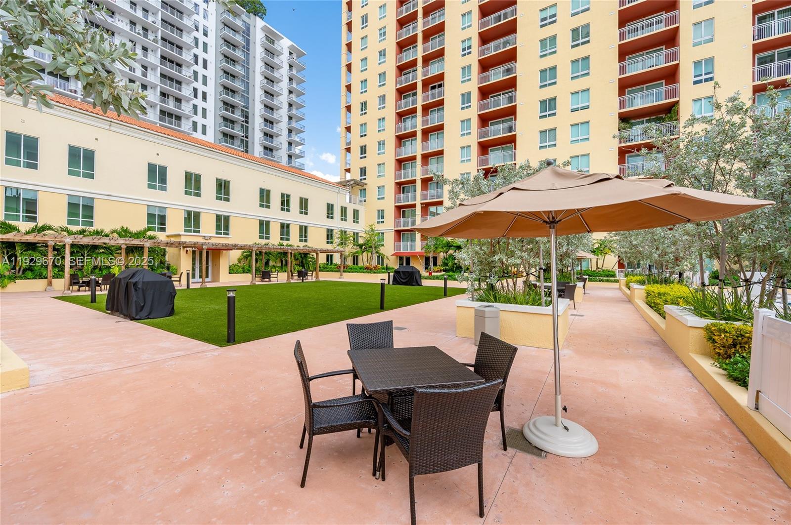 7350 Southwest 89th Street, Unit 1702S Miami, FL 33156 - Photo 26 of 29 a view of a building with a garden and sitting area