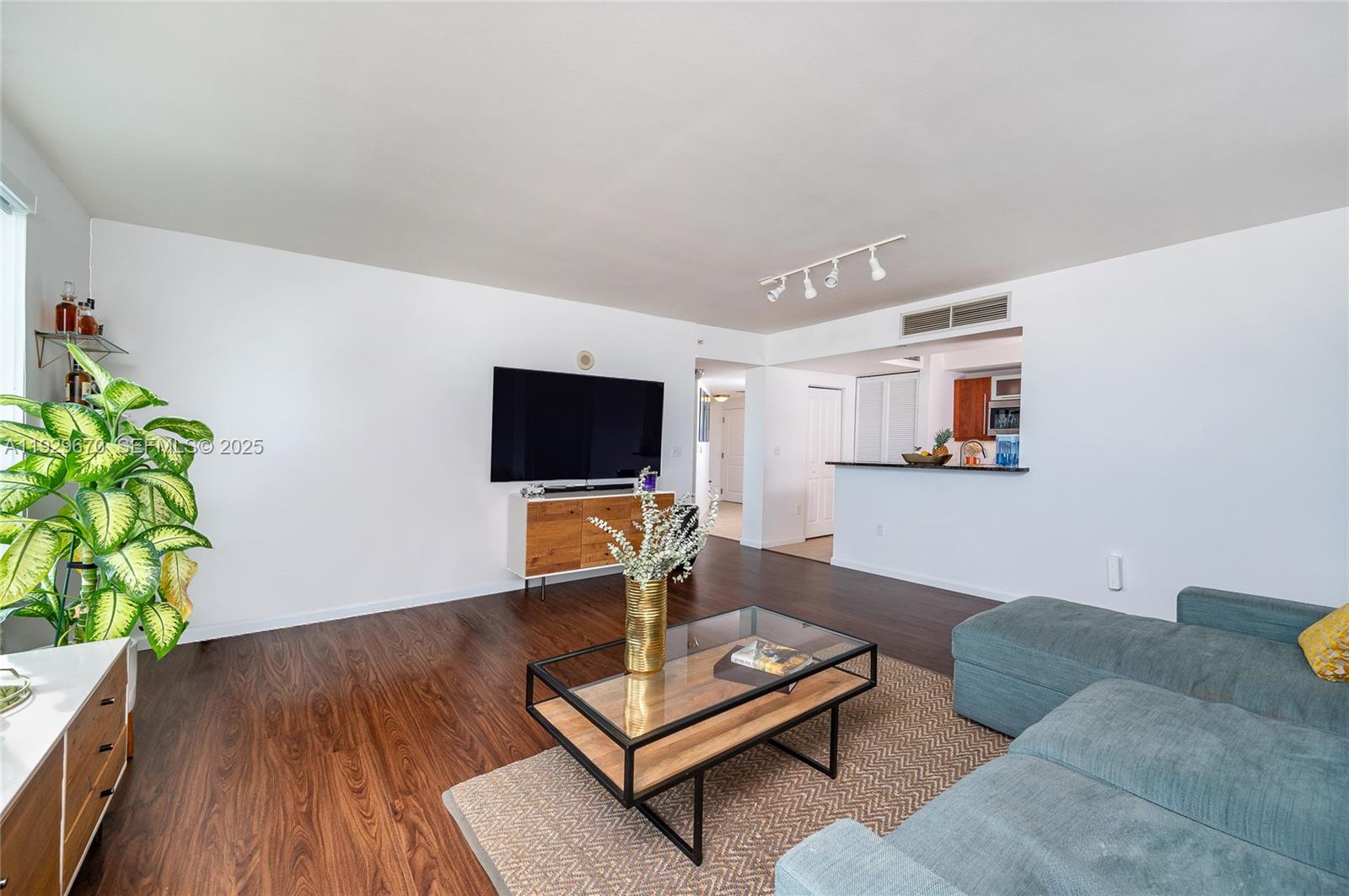 7350 Southwest 89th Street, Unit 1702S Miami, FL 33156 - Photo 5 of 29 a living room with furniture a flat screen tv and a potted plant