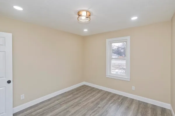 an empty room with wooden floor and a window