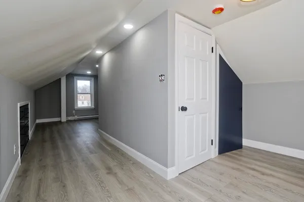 a view of a hallway with wooden floor and closet