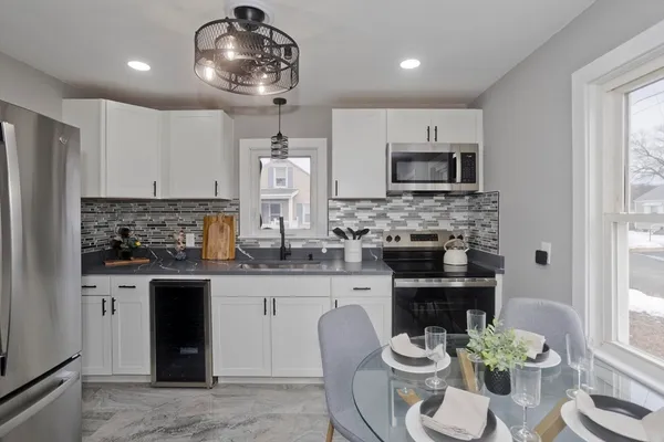a kitchen with stainless steel appliances kitchen island granite countertop a stove refrigerator and microwave