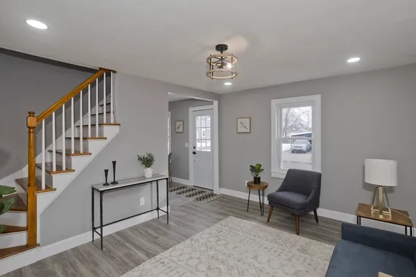 a living room with wooden floor and a dining table
