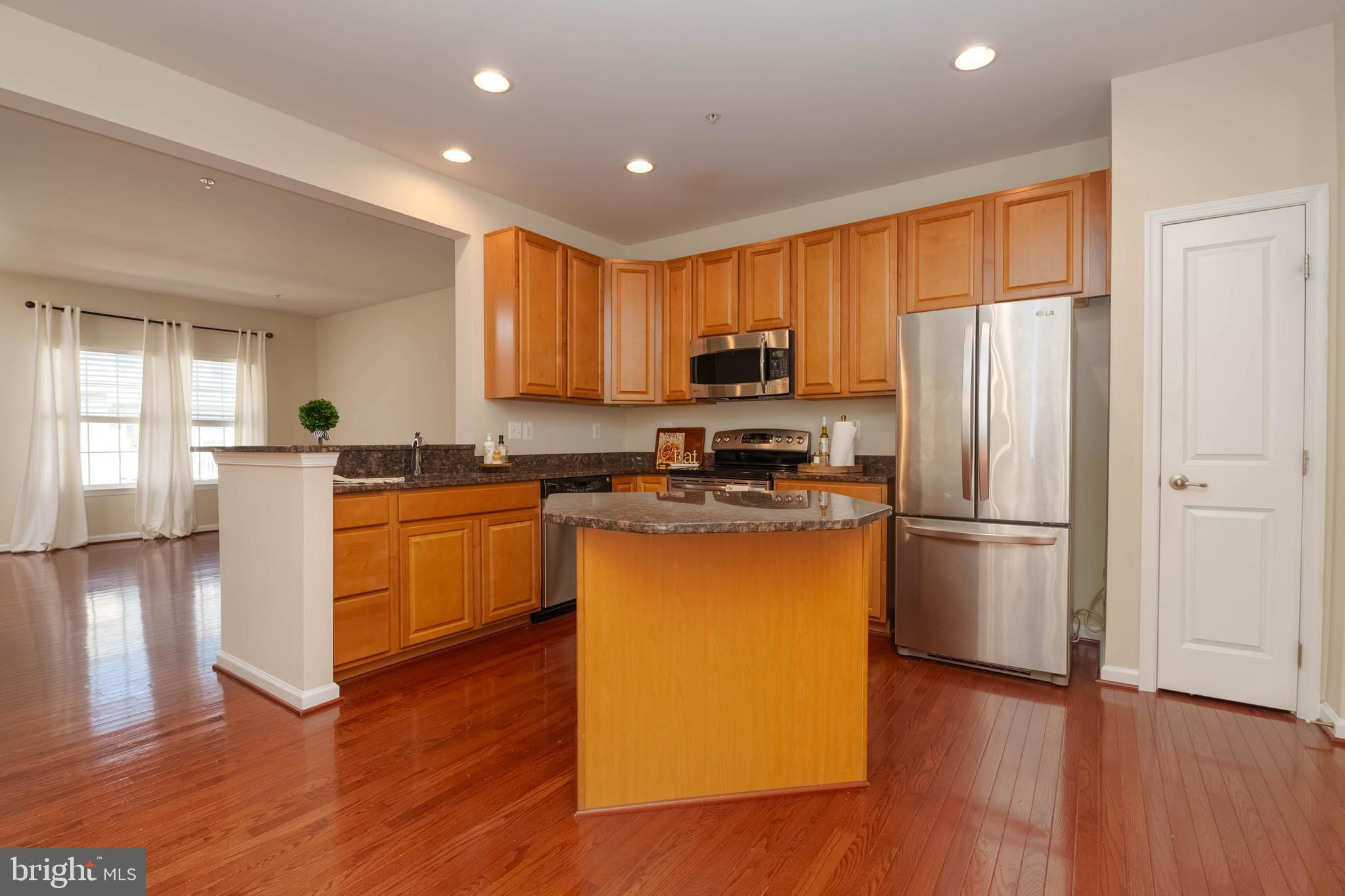 405 Signal Court, Unit 33 Bel Air, MD 21014 - Photo 8 of 43 a kitchen with kitchen island granite countertop wooden floors stainless steel appliances a sink and a window