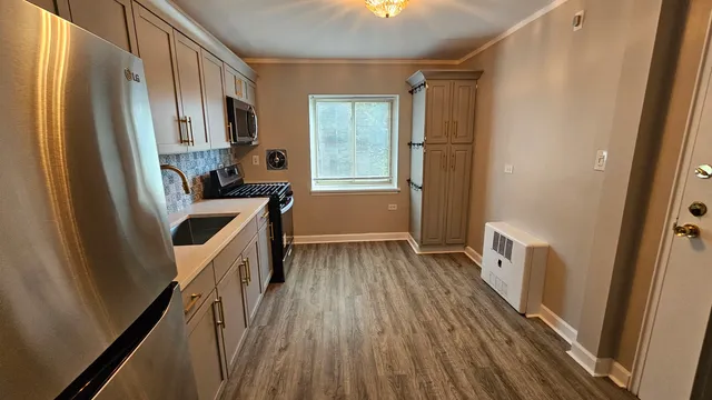 a kitchen with wooden floors and glass door
