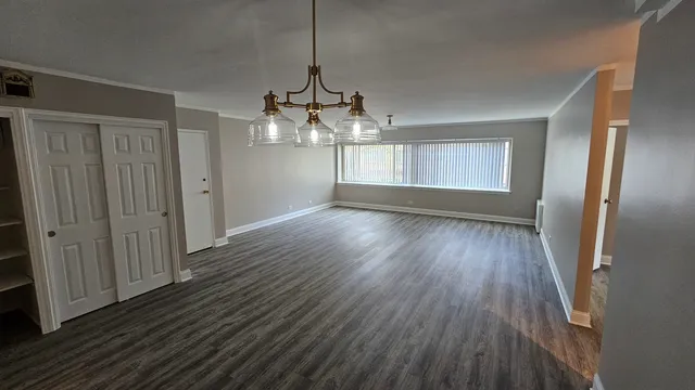 a view of empty room with wooden floor and window