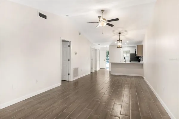 a view of a kitchen with wooden floor and a ceiling fan
