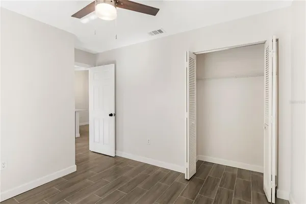 a view of an empty room with wooden floor